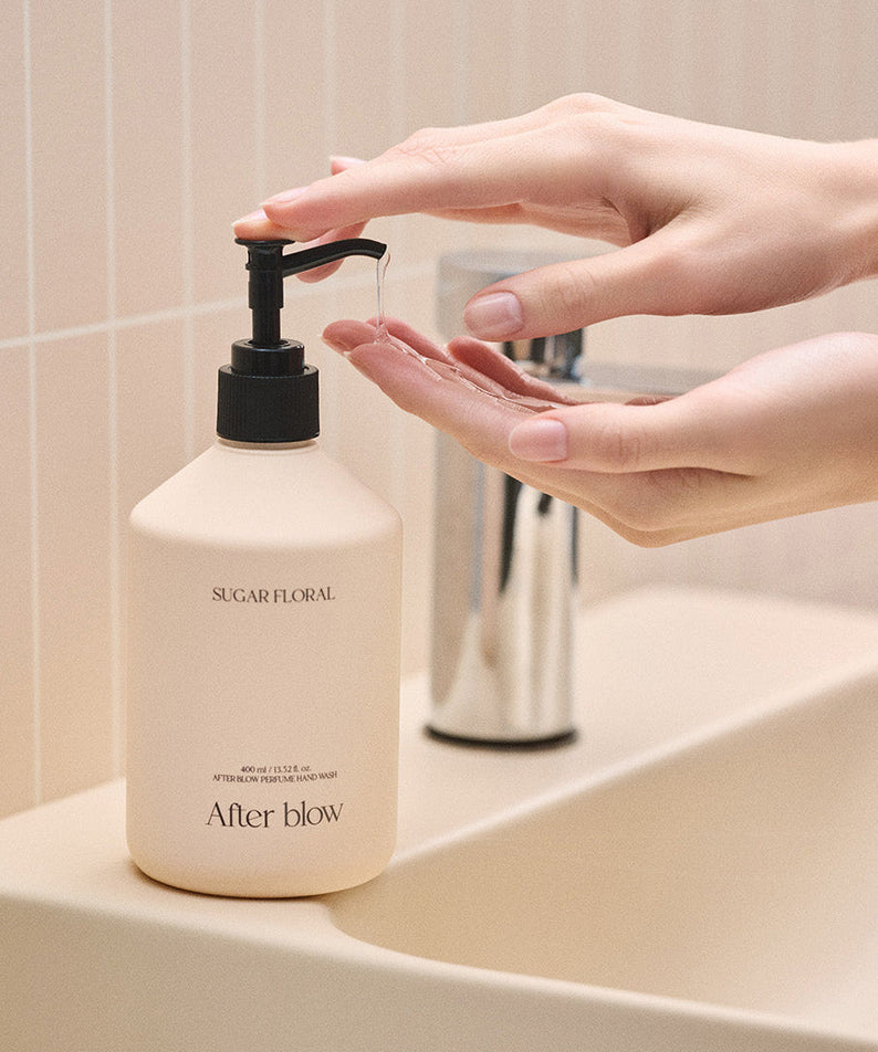 Hands using AFTER BLOW Perfume Hand Wash Sugar Floral 400ml by a sink.