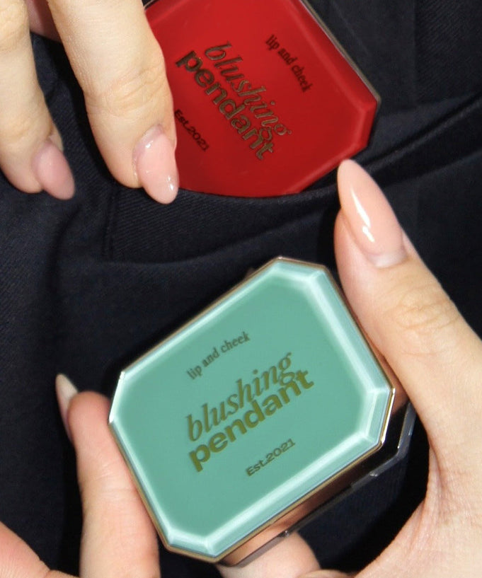 ALTERNATIVE STEREO Blushing Pendant Lip & Cheeck cosmetics held in hand