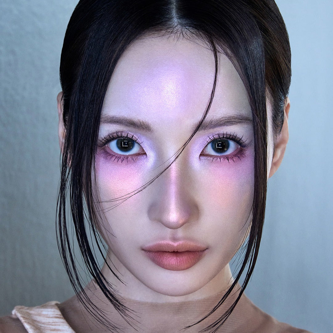 Portrait of a person with striking makeup and illuminated skin