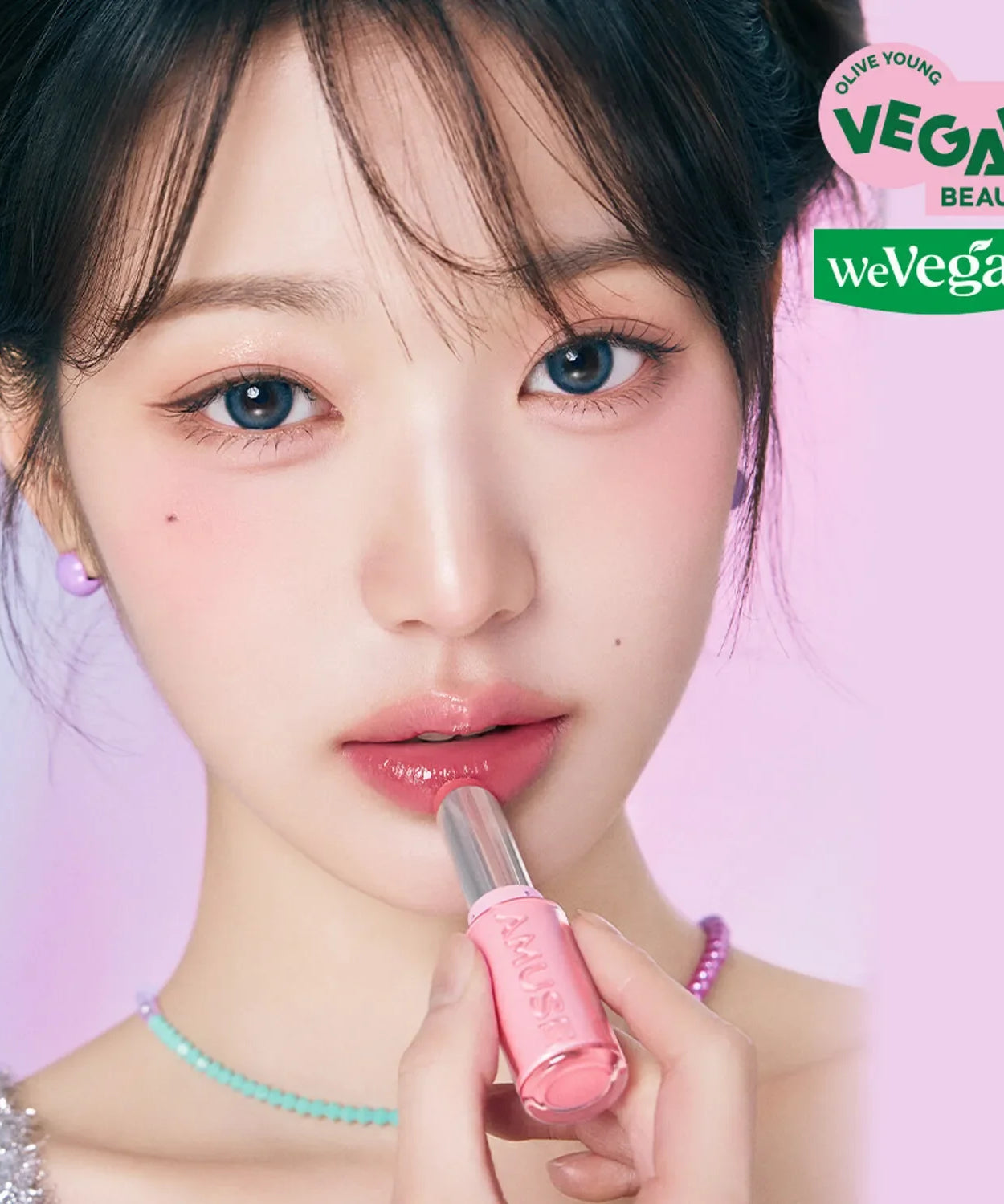 Model applying AMUSE Fondue Balm with a pink shade, highlighting its vegan beauty and smooth texture.