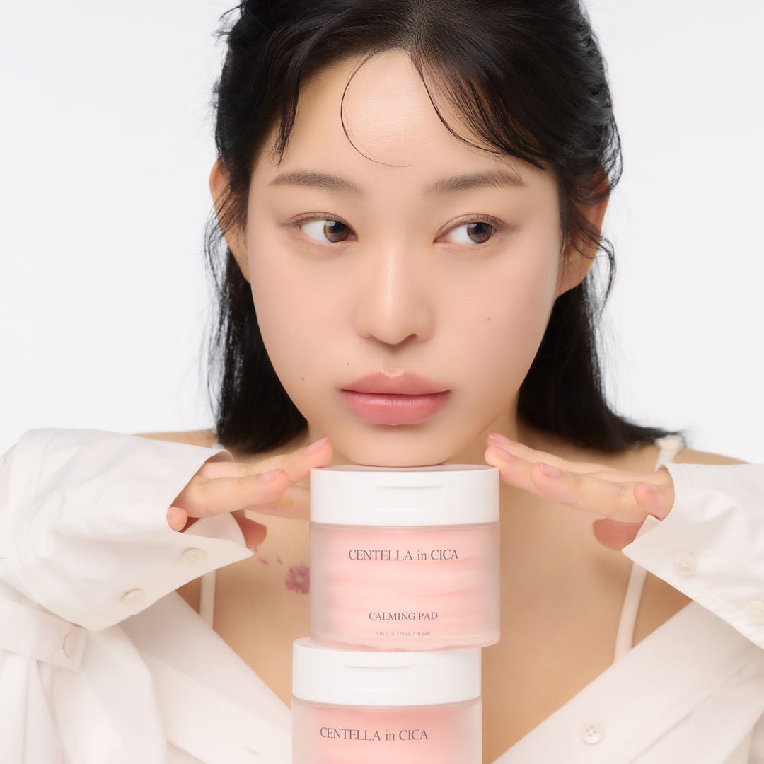Woman holding AND:AR Centellian in Cica Calming Pads, 70 sheets, skincare product on display