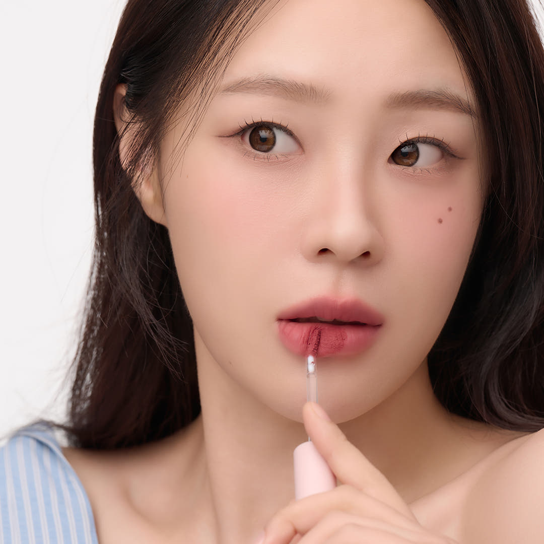 Woman applying AND:AR Matte Lip Color for a natural look