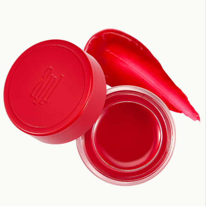 Red ANILLO Petal Glow Balm in a container, with a swatch of color, showcasing a vibrant lip and blush balm.