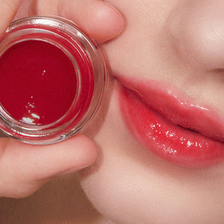 Close-up of lips and ANILLO Petal Glow Balm, showcasing vibrant color and smooth texture.