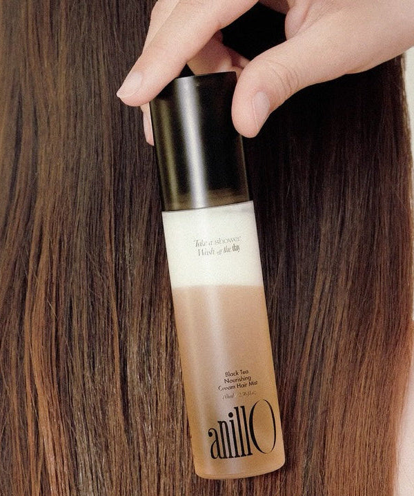 ANILLO Black Tea Nourishing Cream Hair Mist 70ml bottle shown against smooth, straight hair, emphasizing product's nourishing qualities.