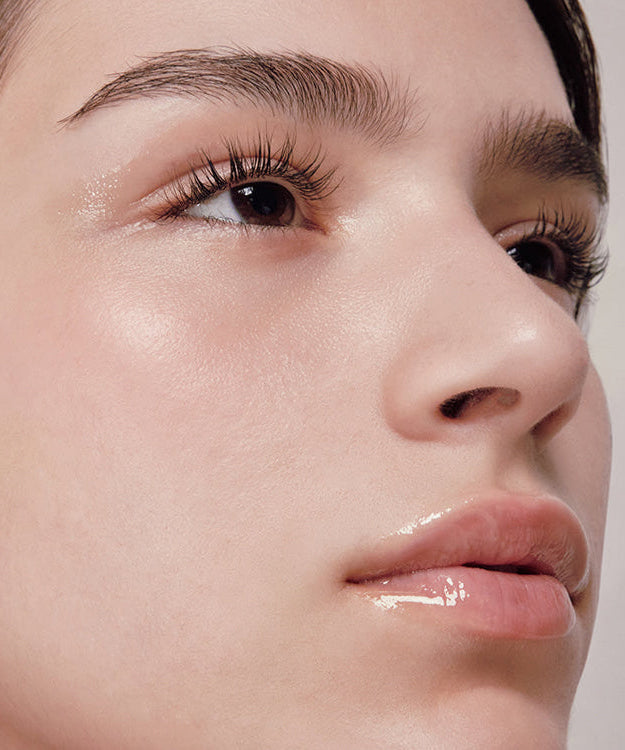 Close-up of a person showcasing a radiant complexion using ANILLO Mellow Glow Balm.