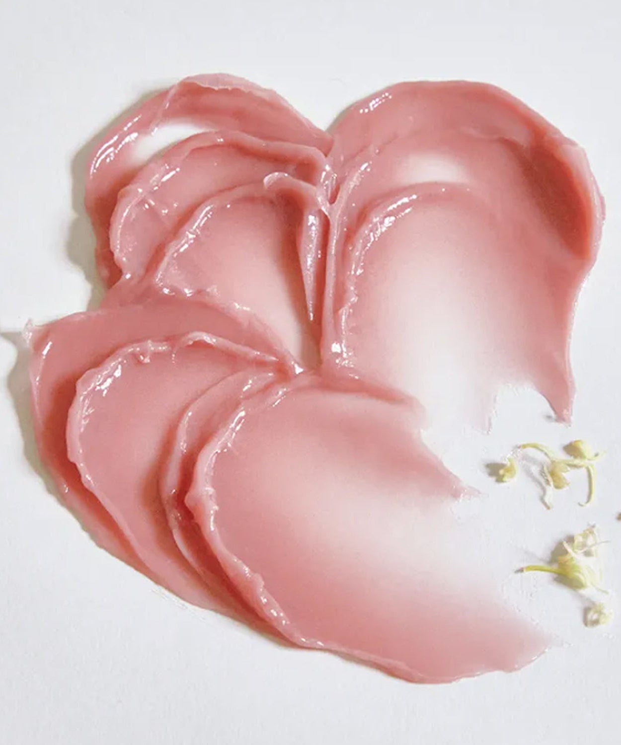 Swatch of ANILLO Rose Glow Balm on a white surface, showcasing its creamy, pink texture and smooth consistency.