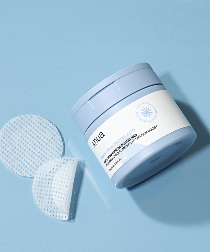 ANUA Birch + Hyaluron Moisture Boosting Pad 70p 160ml skincare product with exfoliating pads on blue background.