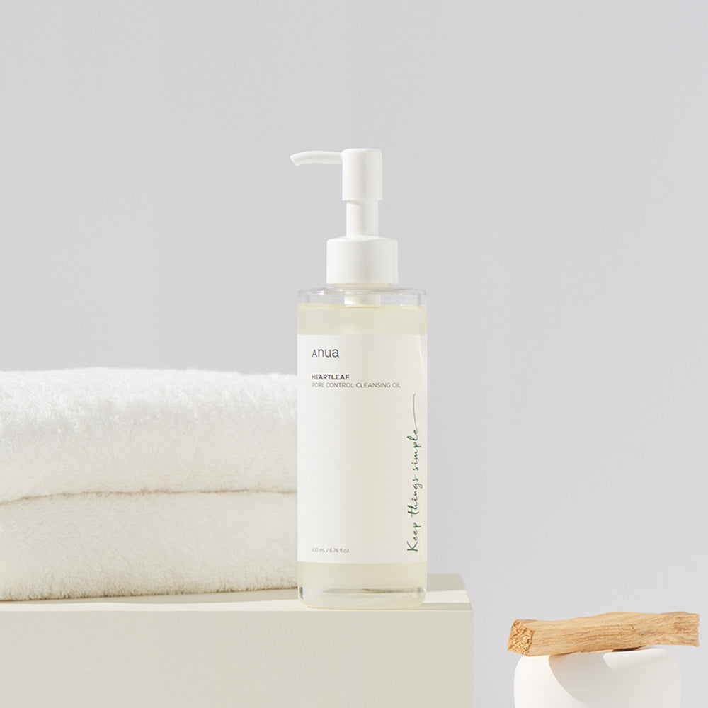 ANUA Heartleaf Pore Control Cleansing Oil 200ml bottle on a bathroom counter with towels in the background