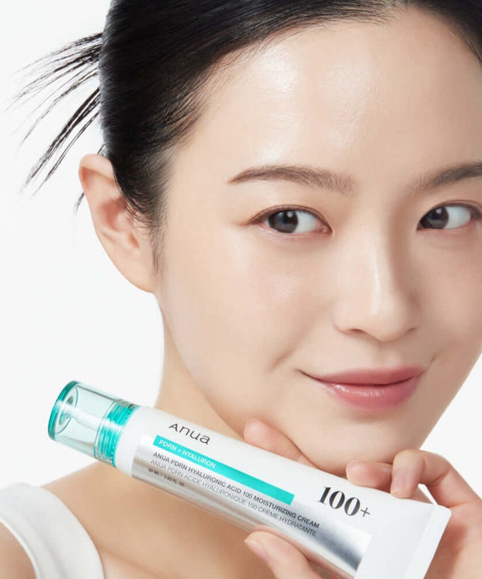 Person holding ANUA PDRN Hyaluronic Acid 100 Moisture Cream tube showcasing skincare product.