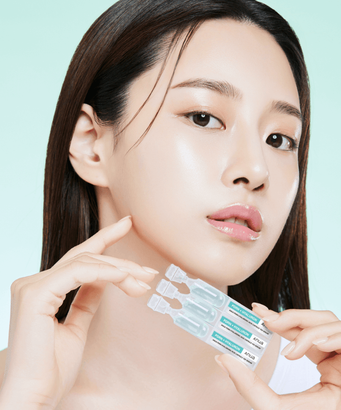 Model holding ANUA PDRN Hyaluronic Acid Capsule 100 Serum against a light background