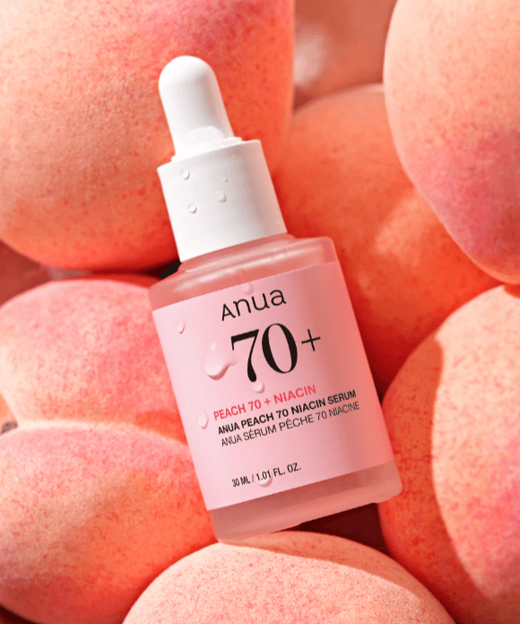 ANUA Peach 70 + Niacin Serum 30ml bottle surrounded by fresh peaches