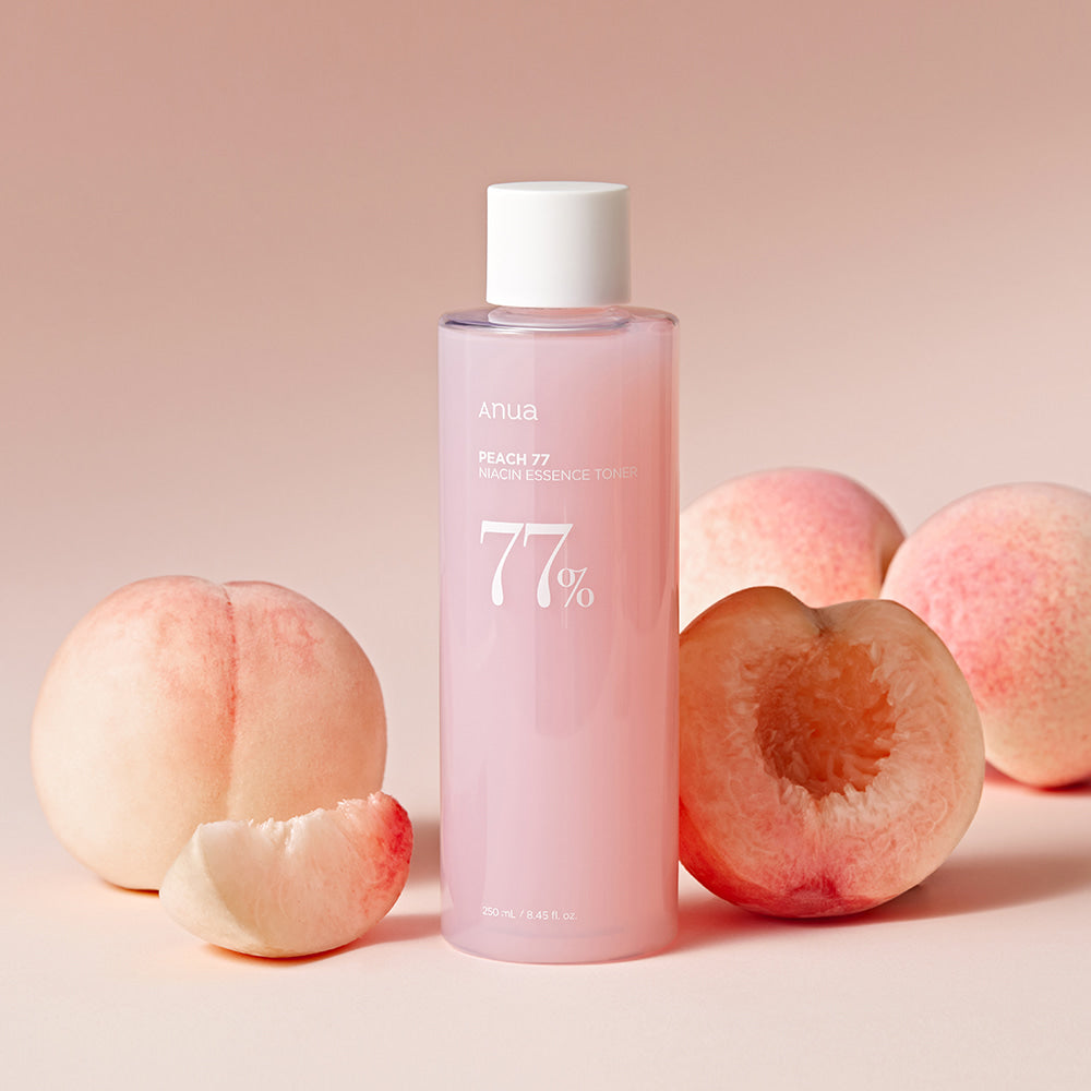 ANUA Peach 77 + Niacin Essence Toner 250ml bottle with fresh peaches background