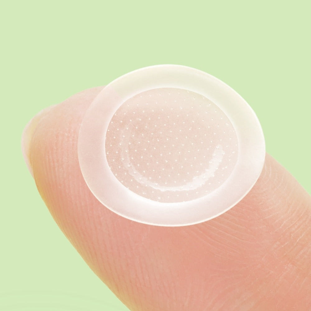 ANUA Triple Acid Spot Care Microdot Patch placed on fingertip against green background