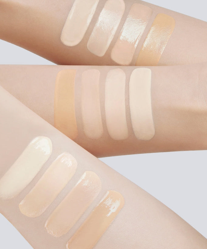 Swatches of various skin tone makeup products on arms showcasing diverse color options.