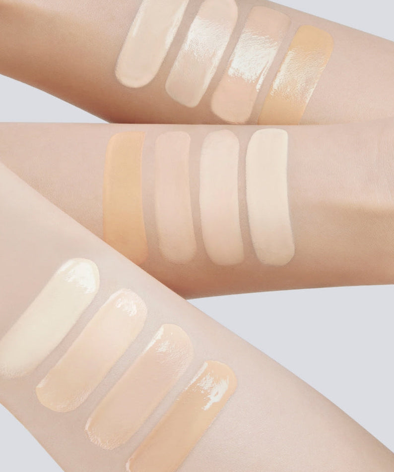 Swatches of various skin tone makeup products on arms showcasing diverse color options.