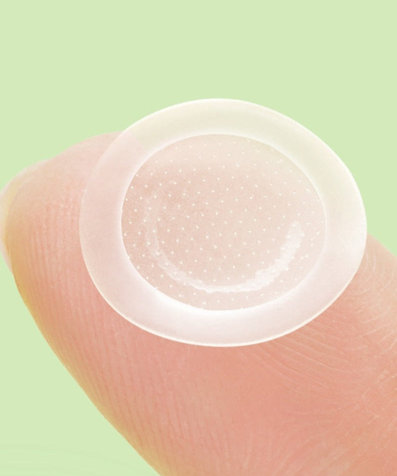 ANUA Triple Acid Spot Care Microdot Patch placed on fingertip against green background