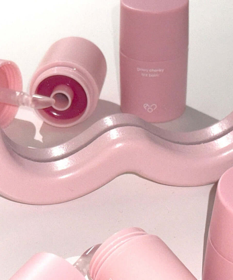 Pink AOU Glowy Chonky Tint Balm tubes with swirled design, showcasing the product's sleek and trendy packaging.