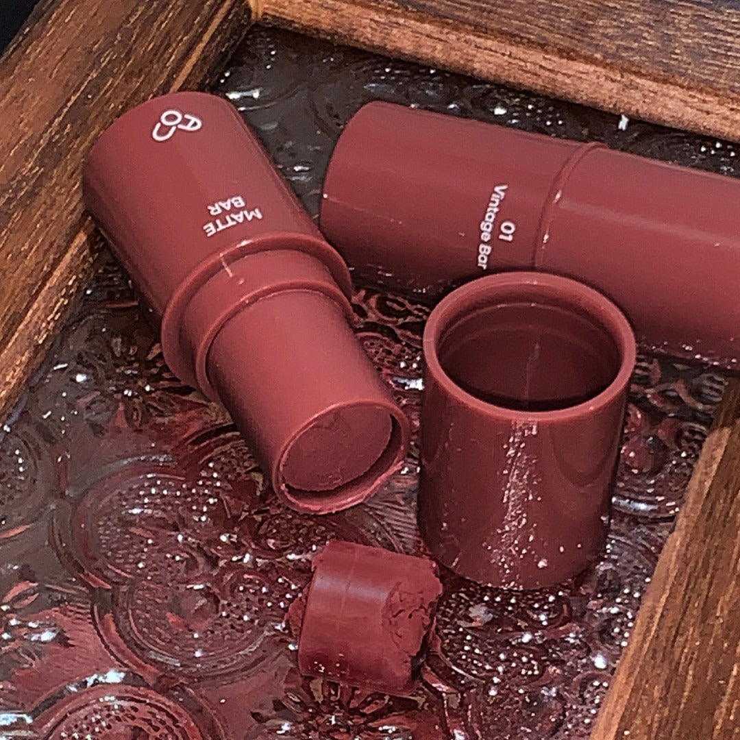 AOU Matte Bar in vintage brown shade displayed on a decorative tray.