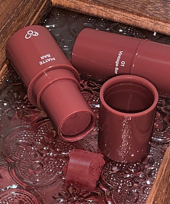 AOU Matte Bar in vintage brown shade displayed on a decorative tray.