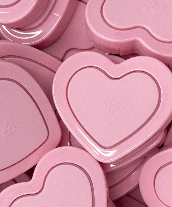 Heart-shaped pink compact cases for AOU Soft Cream Blush stacked together.