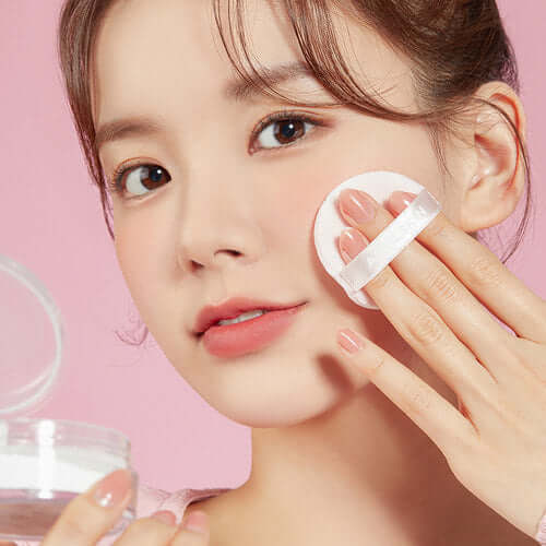 Woman applying APRILSKIN Blur Skin Powder with puff for a smooth, flawless finish.