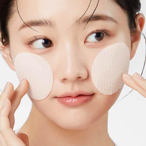 Woman applying APRILSKIN Calendula Hyaluronic Toner Pad on face.