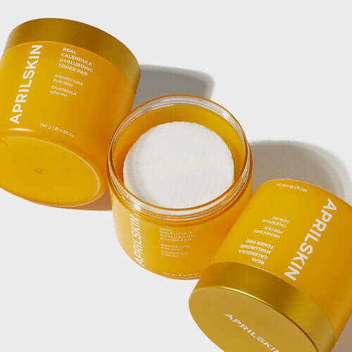 APRILSKIN Calendula Hyaluronic Toner Pad in yellow packaging, open to reveal textured pad inside.