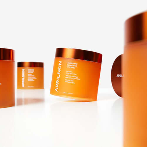 APRILSKIN Carrotene Clarifying Vita Pad displayed on a white surface with other jars in the background.
