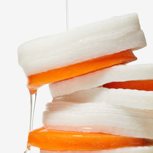 Close-up of APRILSKIN Carrotene Clarifying Vita Pad showing textured layers with liquid infusion.