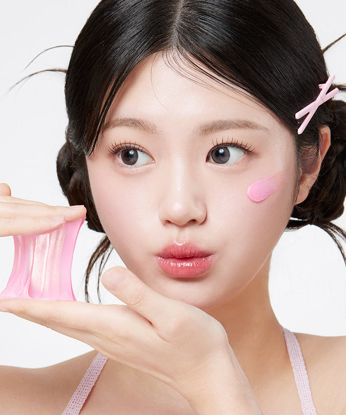 Woman applying skin product, demonstrating APRILSKIN TXA Niacinamide 99 Deep Cleanser 120g features with a playful expression.