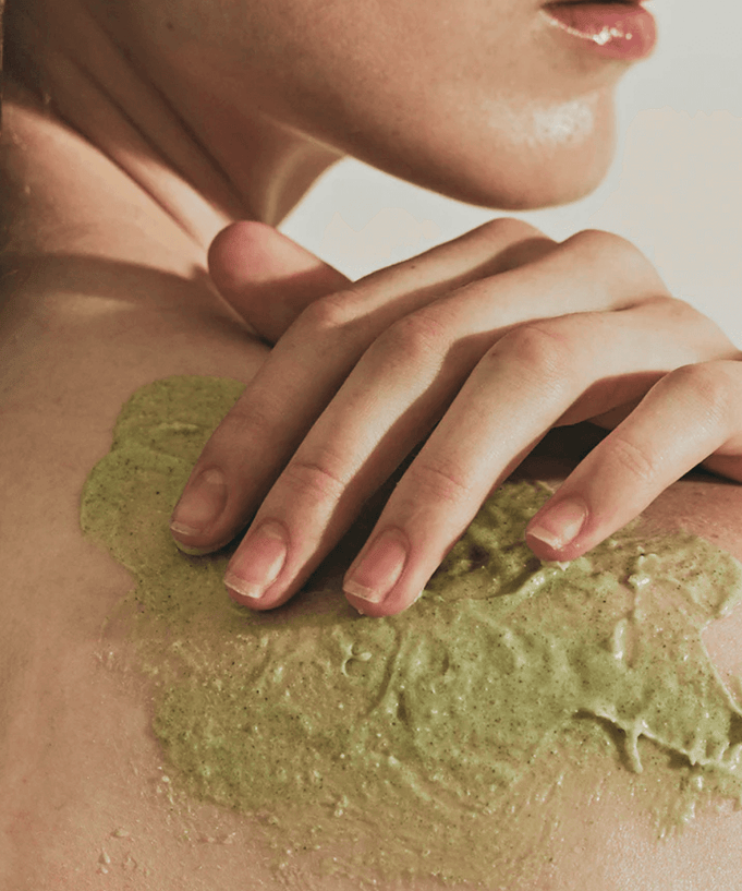 Person applying ARENCIA Fresh Cloud Body Scrub 260g on shoulder, highlighting green texture and moisturizing effect.