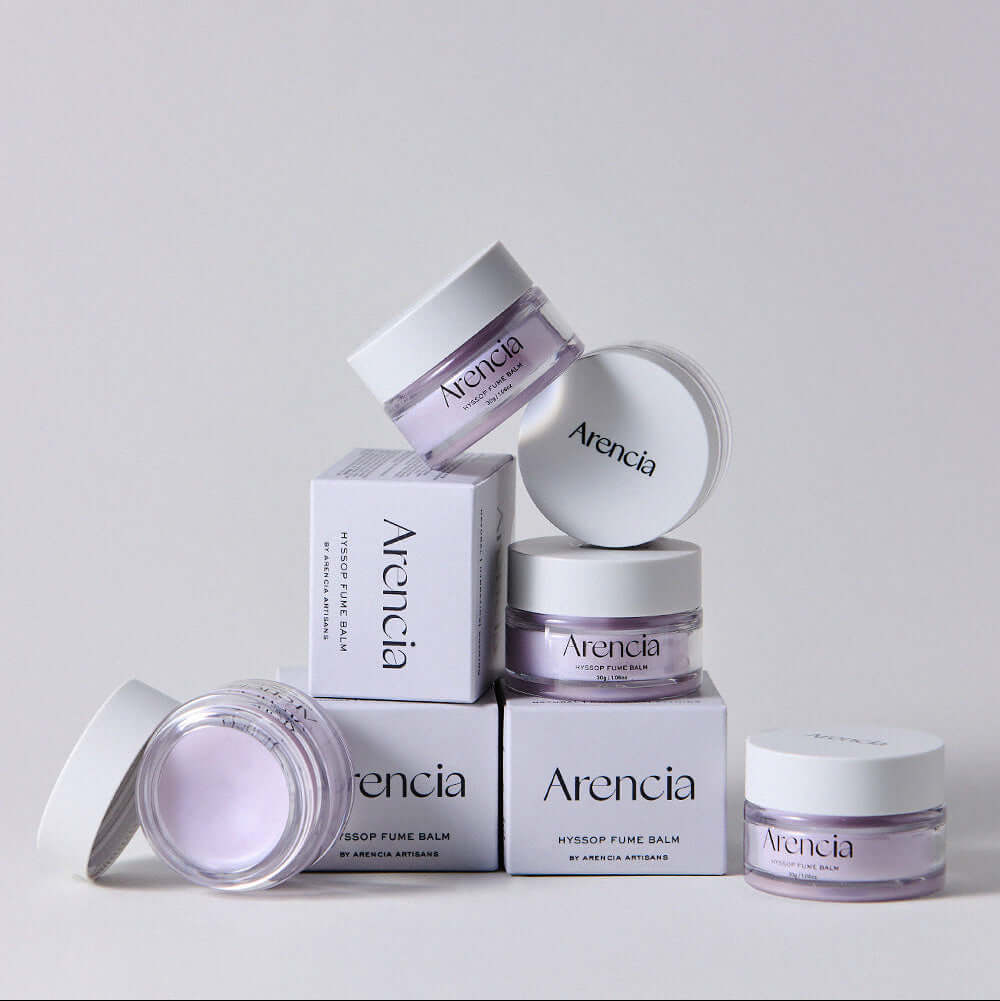 Stacked jars of ARENCIA Hyssop Fume Balm 30g with open and closed lids, showcasing the product's design and packaging.