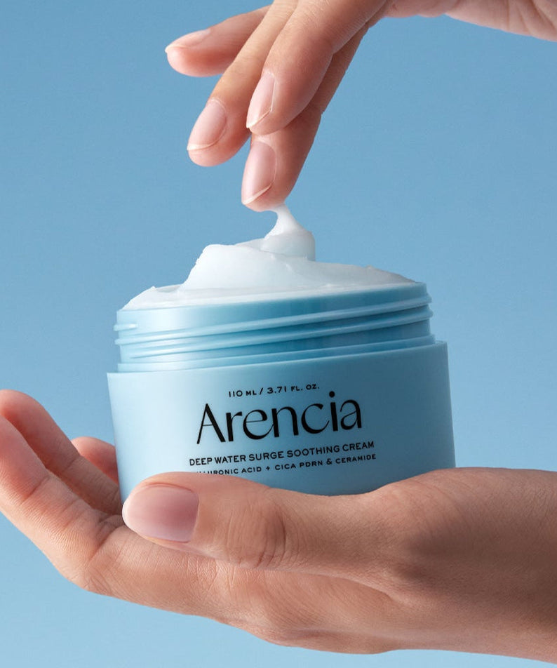 ARENCIA Deep Water Surge Soothing Cream 80ml in open container held in hands against a blue background.