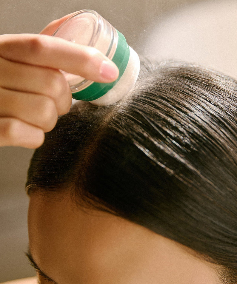 Applying AROMATICA Rosemary Dry Shampoo Powder 10g to hair for a refreshing and oil-free look.