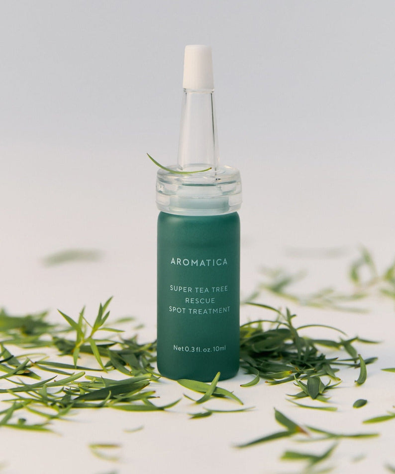 AROMATICA Super Tea Tree Rescue Spot Treatment 10ML product bottle surrounded by tea tree leaves