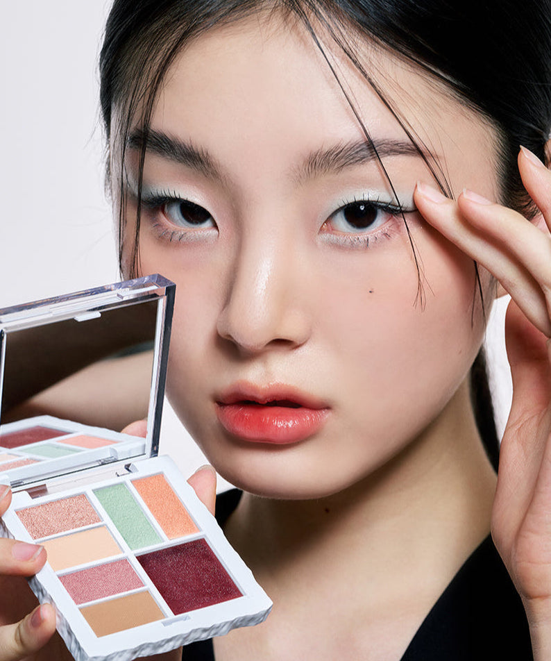 Model holding ARTESINSA Unvoiced Eye Palettes showcasing different eyeshadow colors.