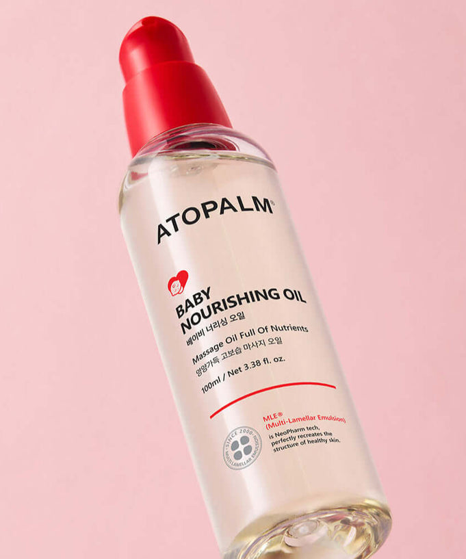 ATOPALM Baby Nourishing Oil 100ml bottle on pink background.