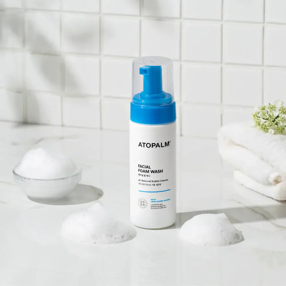ATOPALM Facial Foam Wash 150ml displayed on a bathroom counter with bubbles and towels, perfect for gentle skin cleansing.