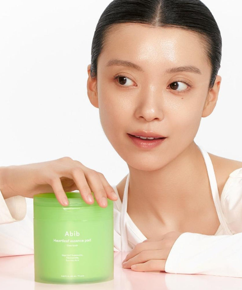 Woman using ABIB Eoseongcho Trace Essence Pad Clear Touch 70 Sheets (+70 Sheets Refill + Buckle Pouch) for skincare routine