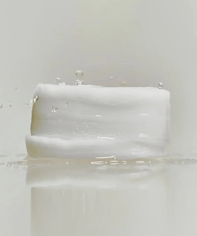 ABIB Jericho Rose Collagen Pad Firming Touch 60 Pads reflecting light with water droplets on a white background.