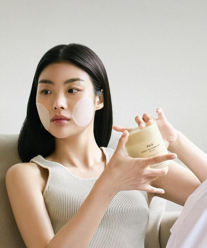 Woman using ABIB Jericho Rose Collagen Pad Firming Touch 60 Pads for skincare routine