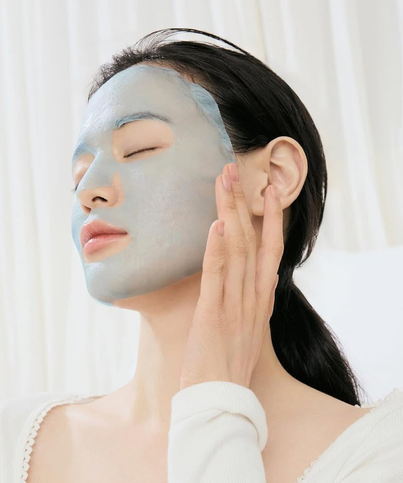 Woman applying DR.ALTHEA Aqua Blue Hydrating Mask (4ea) for skin hydration.