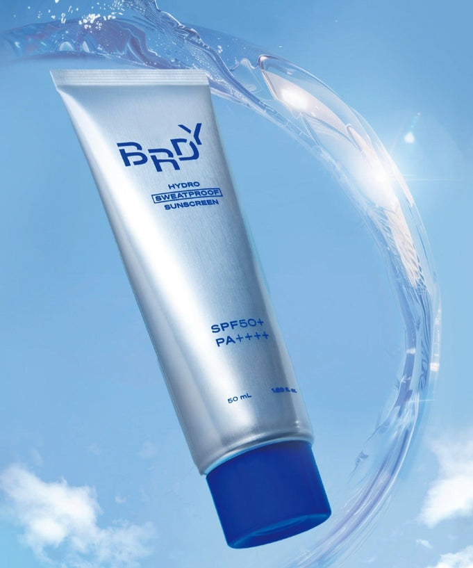 B.READY Hydro Sweatproof Sunscreen 50ml in a sleek silver tube with blue accents on a sky blue background.