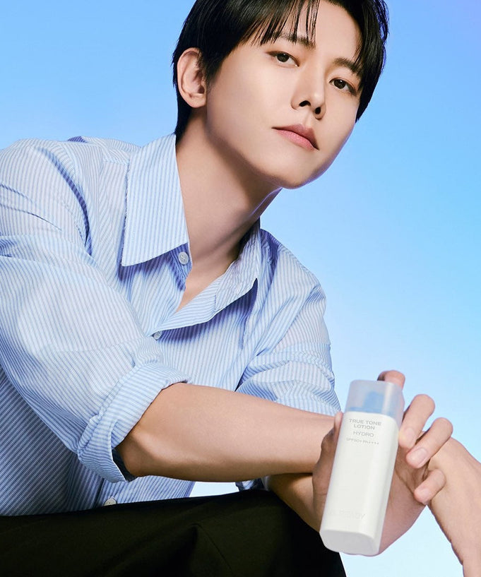 Person holding B.READY True Tone Lotion 2.0 40ml against blue background