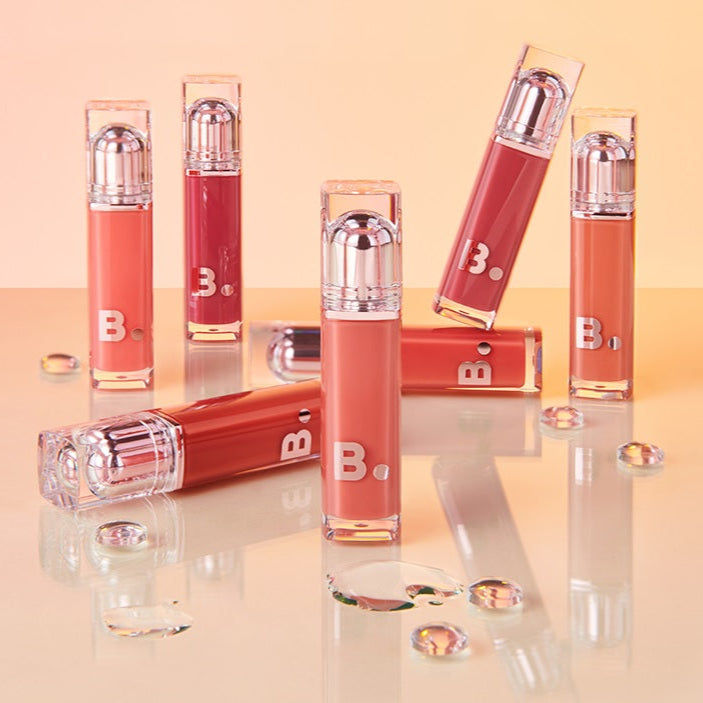 Collection of BANILA CO Dew Glow Tint lip products on display with various shades.