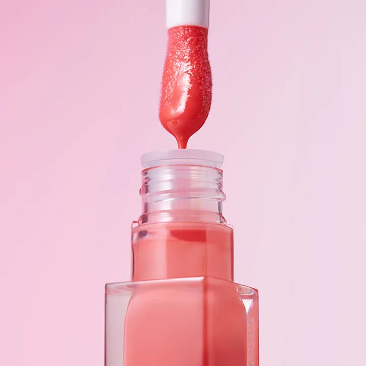BANILA CO Hydrating Lip Oil with open applicator against pink background