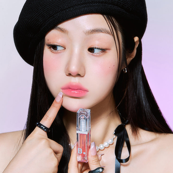 Model showcasing BANILA CO Volume Lip Plumper with a glossy finish, enhancing natural lip volume, in a stylish beauty shot.