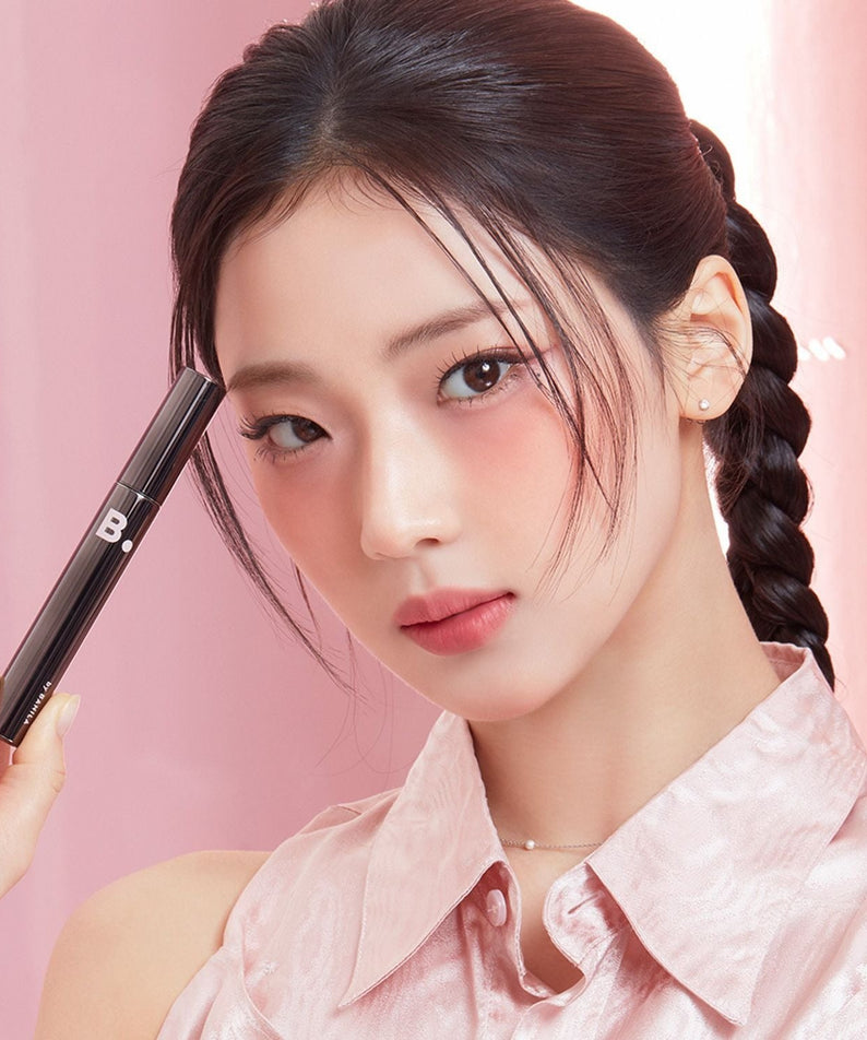 Model holding BANILACO Powerproof Mascara in elegant pink setting