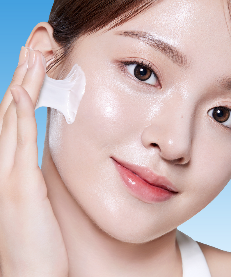 Model applying BANOBAGI PDRN 1000 Anti-Aging Cream 50ml to face on a blue background.